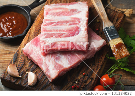 Raw pork ribs with spices, salt and rosemary on dark wooden background 131384022