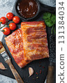 Ready for BBQ raw pork spare ribs with barbecue sauce. Black background. Top view 131384034