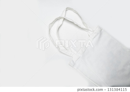 Top view of an eco-friendly white cotton canvas tote bag on a white background. Mockup, template, or copy space. Reusable bag for groceries and shopping Top view of an eco-friendly white cotton canvas tote bag on a white background. Mockup, template, or copy space. Reusable bag for groceries and shopping 131384115