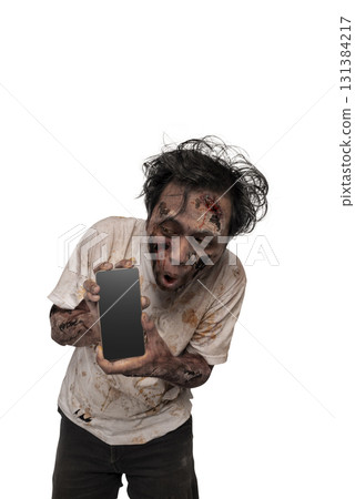 Portrait of a scary male zombie with a wound and blood on the body holding a cellphone isolated over a white background. Mockup or Copy space. Spooky expression. Concept of Halloween or Horror Portrait of a scary male zombie with a wound and blood on the body holding a cellphone isolated over a white background. Mockup or Copy space. Spooky expression. Concept of Halloween or Horror 131384217
