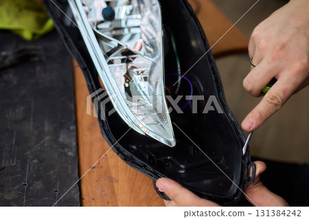 Careful precision is essential when installing a car headlight assembly for optimal performance 131384242