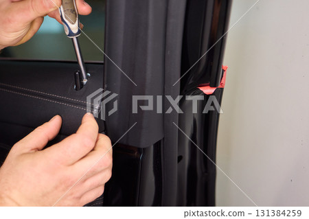 Skilled hands install a car door handle trim, highlighting craftsmanship and precision in design Skilled hands install a car door handle trim, highlighting craftsmanship and precision in design 131384259
