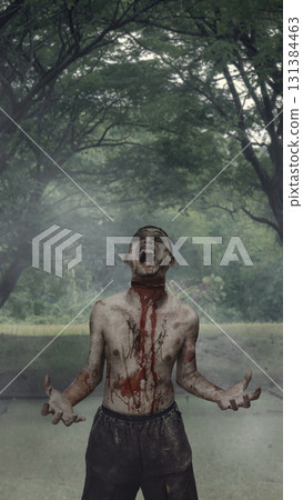 Scary male zombie with a wound and blood walking on the street surrounded by trees. The scene is scary and creepy. Dramatic smoke or fog effect. Concept of Spooky Halloween Scary male zombie with a wound and blood walking on the street surrounded by trees. The scene is scary and creepy. Dramatic smoke or fog effect. Concept of Spooky Halloween 131384463