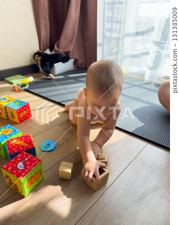 Baby Playing with Wooden Blocks on Floor Baby Playing with Wooden Blocks on Floor 131385009