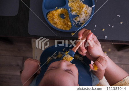 Baby Eating Rice and Eggs with Spoon 131385044