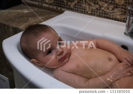 Baby Bathing in Sink with Pink Ball Baby Bathing in Sink with Pink Ball 131385050