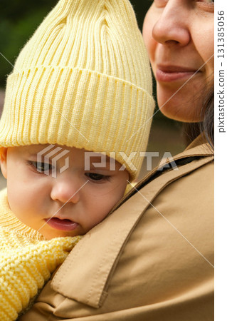 Mother Holding Baby in Yellow Outfit at Park Mother Holding Baby in Yellow Outfit at Park 131385056
