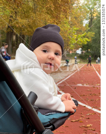 Baby in Hoodie on Track Field in Autumn 131385074