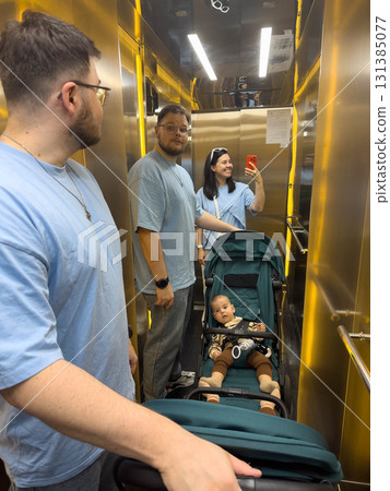 Family in Elevator with Stroller and Mirrors Family in Elevator with Stroller and Mirrors 131385077