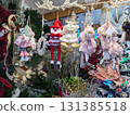 Hanging handmade Christmas dolls and festive winter decorations displayed for sale in a vibrant holiday market 131385518