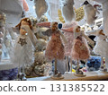 Christmas angel dolls and festive decorations displayed in a shop window, featuring winter holidays and magic concept 131385522