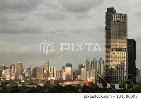 Modern skyscrapers against a cloudy sky during what appears to be sundown in Bangkok. 131386608