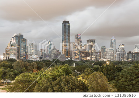 a modern Bangkok city skyline in the evening, featuring illuminated skyscrapers set against a cloudy sky. a modern Bangkok city skyline in the evening, featuring illuminated skyscrapers set against a cloudy sky. 131386610