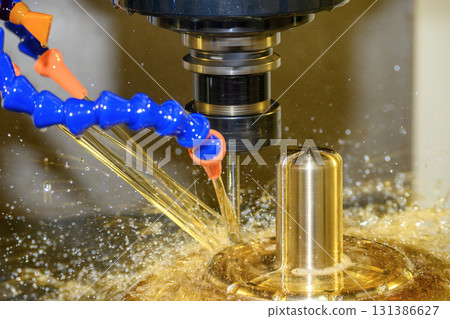 Close up scene the CNC milling machine finishing cut the brass shell mold parts with oil coolant method. Close up scene the CNC milling machine finishing cut the brass shell mold parts with oil coolant method. 131386627