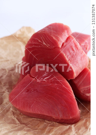 Tuna slices on white plate. Steaks from fresh tuna fillet. An isolated object. White background.Close-up.Vertical photo. Tuna slices on white plate. Steaks from fresh tuna fillet. An isolated object. White background.Close-up.Vertical photo. 131387074