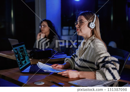 Two women are sitting on the business event, with laptops 131387098