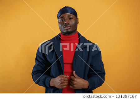 Serious facial expression. Handsome black man is in the studio against yellow background Serious facial expression. Handsome black man is in the studio against yellow background 131387167