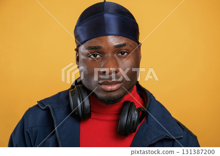 Serious facial expression. Handsome black man is in the studio against yellow background 131387200