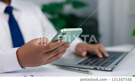Businessman using smartphone and laptop for online communication and digital finance concept Businessman using smartphone and laptop for online communication and digital finance concept 131387588