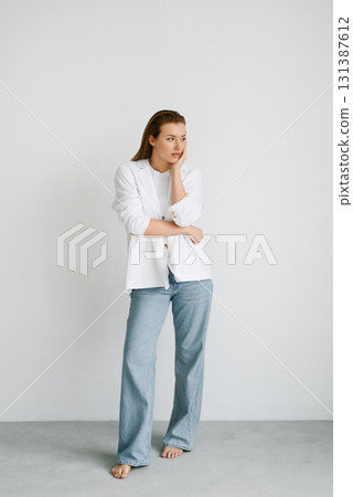 Young Woman In White Jacket And Jeans Indoors Young Woman In White Jacket And Jeans Indoors 131387612