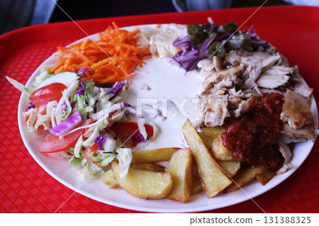 fast food. Shawarma on a plate, meat, potatoes, vegetables with white sauce on a plate fast food. Shawarma on a plate, meat, potatoes, vegetables with white sauce on a plate 131388325