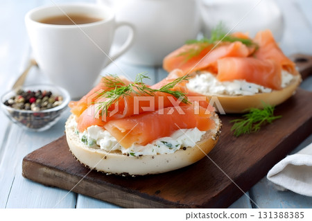 Two delicious bagels with cream cheese and smoked salmon are ready to eat. Two delicious bagels with cream cheese and smoked salmon are ready to eat. 131388385