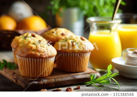 Fresh muffins and orange juice are ready for a delicious breakfast. Fresh muffins and orange juice are ready for a delicious breakfast. 131388588