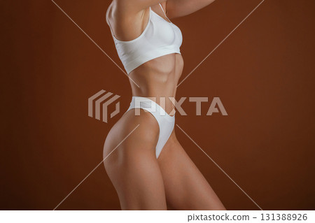 Fashion model. Woman with slim body shape is posing against background 131388926