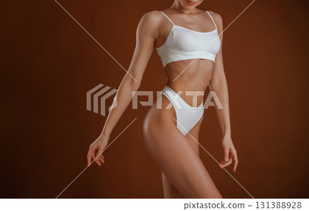 Fashion model. Woman with slim body shape is posing against background Fashion model. Woman with slim body shape is posing against background 131388928