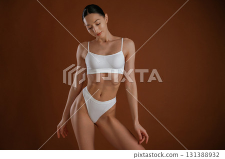 Fashion model. Woman with slim body shape is posing against background Fashion model. Woman with slim body shape is posing against background 131388932