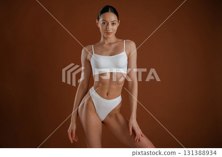 Fashion model. Woman with slim body shape is posing against background Fashion model. Woman with slim body shape is posing against background 131388934