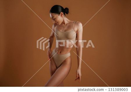 Fitness slim body shape. Woman is posing against background Fitness slim body shape. Woman is posing against background 131389003