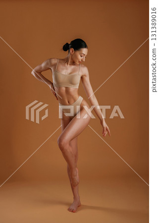 Beautiful model. Woman with slim body shape is posing against background Beautiful model. Woman with slim body shape is posing against background 131389016
