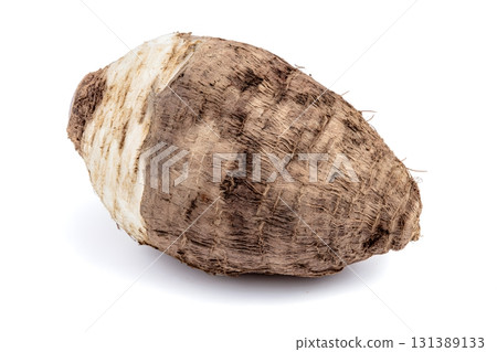 A single taro root vegetable sits isolated on a white background. A single taro root vegetable sits isolated on a white background. 131389133