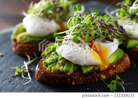 Avocado toast with poached eggs and sprouts is a delightful breakfast. 131389135