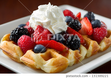 Waffles topped with berries and cream make a delightful breakfast. Waffles topped with berries and cream make a delightful breakfast. 131389221