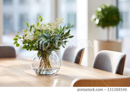 Elegant desk plant decor in a clear vase on a wooden table with natural light ambiance Elegant desk plant decor in a clear vase on a wooden table with natural light ambiance 131389340