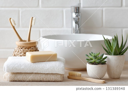 Modern bathroom setup featuring natural elements, towels, and eco-friendly toiletries for relaxation 131389348
