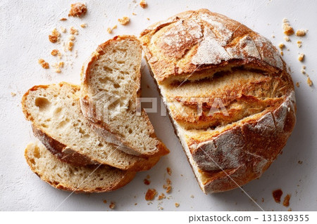 Freshly baked artisan bread loaf with sliced pieces showcasing crusty texture and soft interior 131389355