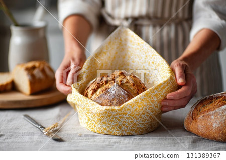 Reusable beeswax wraps showcasing fresh bread in a cozy kitchen setting with natural textures 131389367