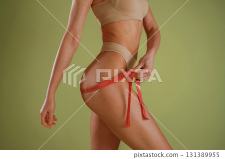 Woman with slim body shape is posing against background Woman with slim body shape is posing against background 131389955