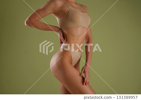 Side close up view. Woman with slim body shape is posing against background 131389957