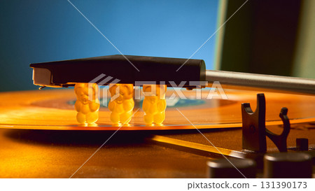 Gummy bears pressed under needle of retro vinyl record player with surreal emotion 131390173