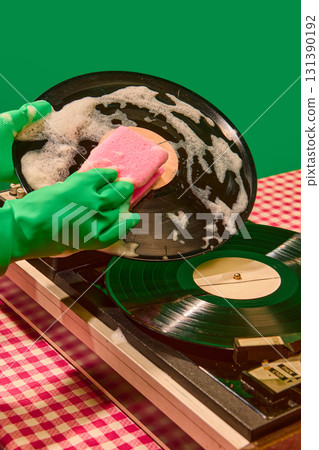 Close up hand washing vinyl record on retro player with pink sponge Close up hand washing vinyl record on retro player with pink sponge 131390192