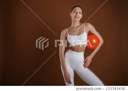 With red ball. Beautiful fitness woman is in the studio With red ball. Beautiful fitness woman is in the studio 131391430
