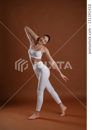 Female, front view, smiling. Beautiful fitness woman is in the studio Female, front view, smiling. Beautiful fitness woman is in the studio 131391458
