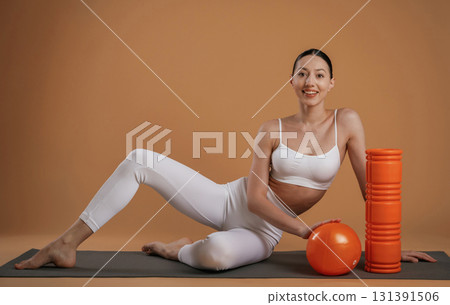 On the floor, sitting. Beautiful fitness woman is in the studio 131391506