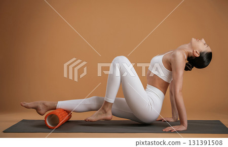 Exercises on yoga mat. Beautiful fitness woman is in the studio Exercises on yoga mat. Beautiful fitness woman is in the studio 131391508