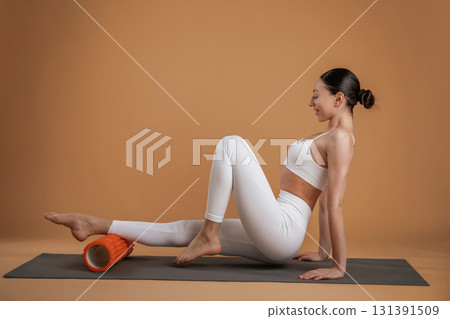 Exercises on yoga mat. Beautiful fitness woman is in the studio 131391509