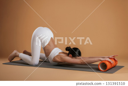 Exercises on yoga mat. Beautiful fitness woman is in the studio 131391510